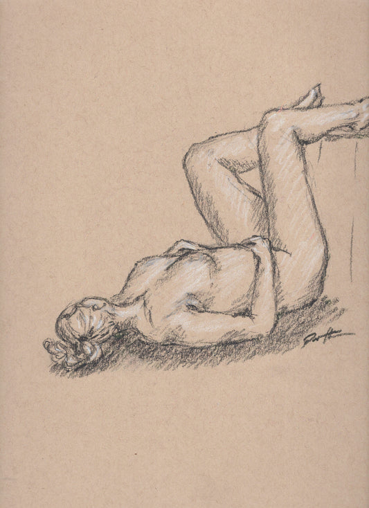 Charcoal drawing on toned paper of a nude figure drawn from a live model. The lady is lying on the floor with her legs up.