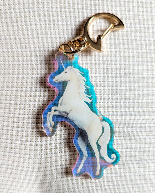Two sided Unicorn keychain with iridescent rainbow effects and gold moon-shaped clasp. 
